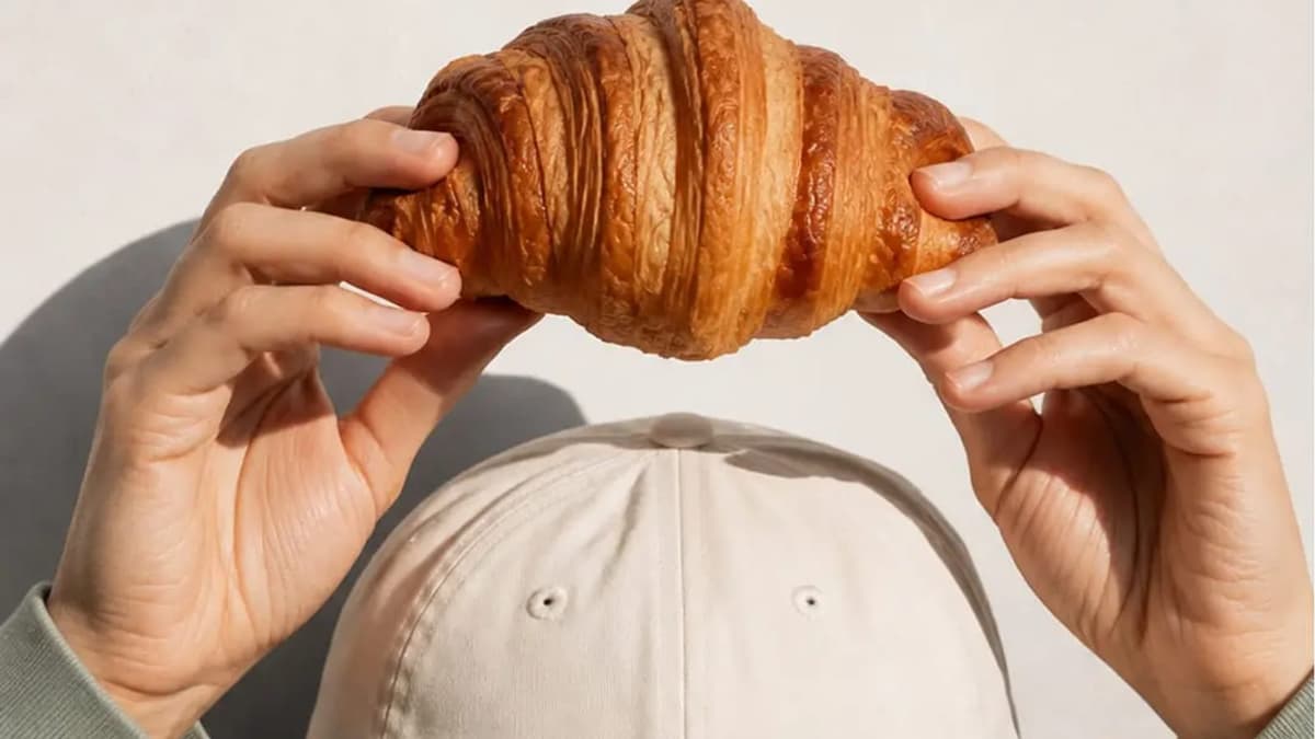 a croissant holding above a cap
